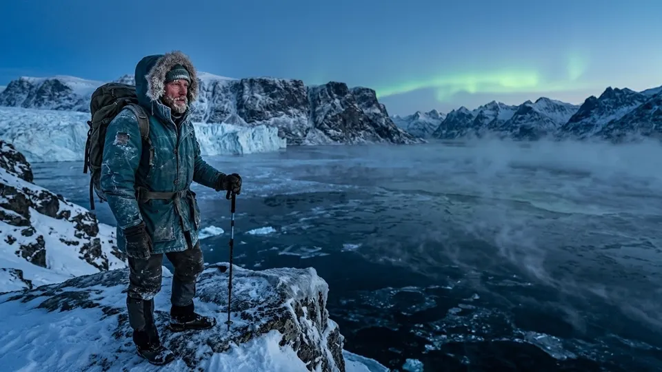 a lone explorer in a worn teal parka, weathered face with frost on the eyebrows